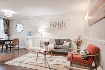 a living room with a couch and chairs and a sign on the wall